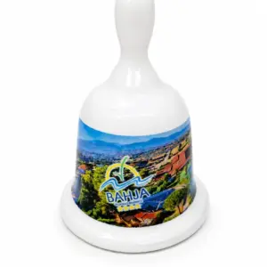 Campanella ceramica bianca con paesaggio costiero Villaggio Bahja, manico arrotondato e logo blu giallo