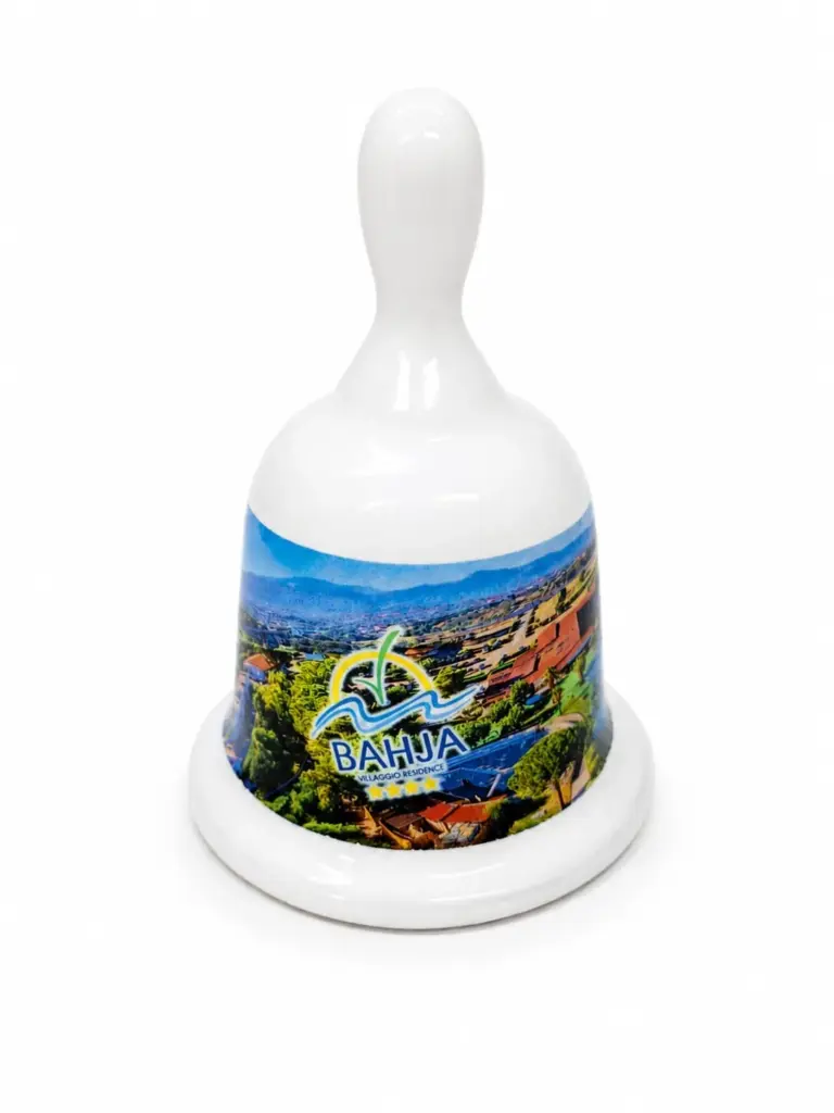 Campanella ceramica bianca con paesaggio costiero Villaggio Bahja, manico arrotondato e logo blu giallo
