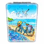 Specchietto rettangolare con bicicletta azzurra sulla spiaggia, mare turchese e glitter blu decorativi