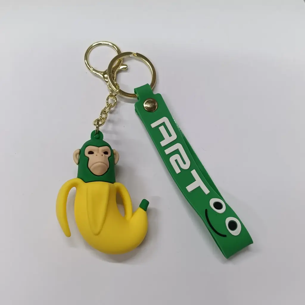 Portachiavi gomma scimmietta gialla vestita da banana con ciondolo verde ART00
