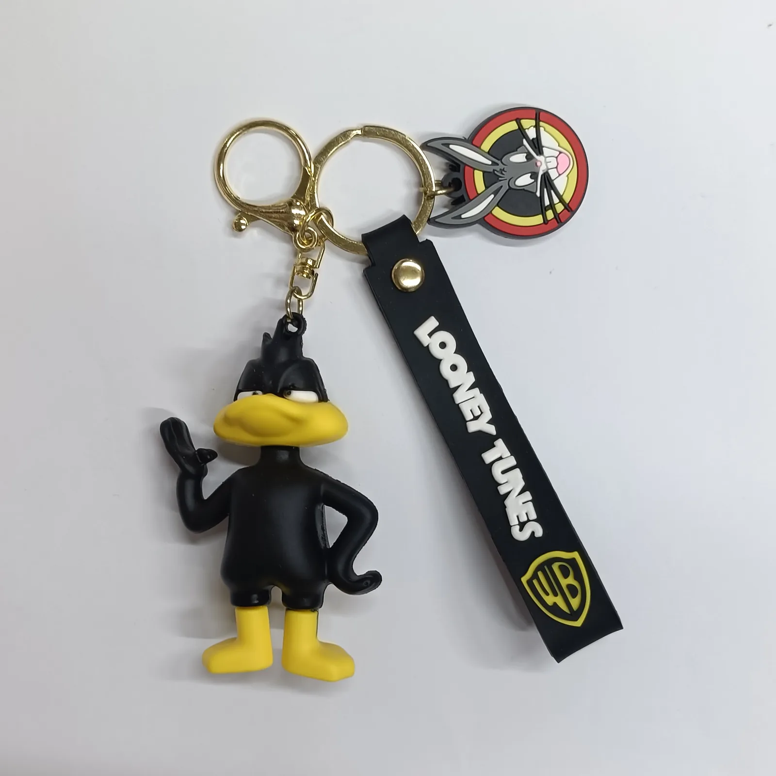 Portachiavi Daffy Duck in gomma nera con nastro Looney Tunes e badge colorato su sfondo bianco