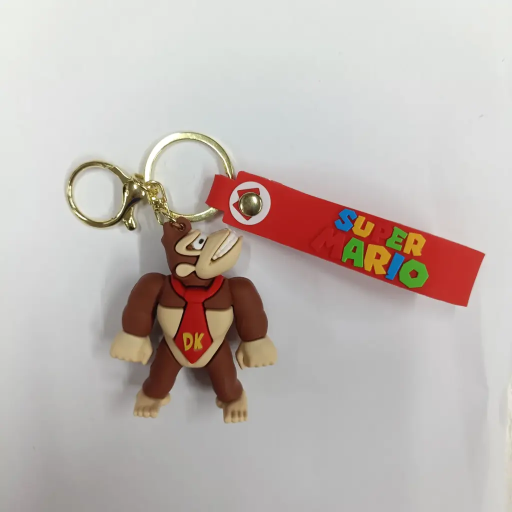 Portachiavi in gomma Donkey Kong con cravatta rossa, corpo marrone e tag Super Mario