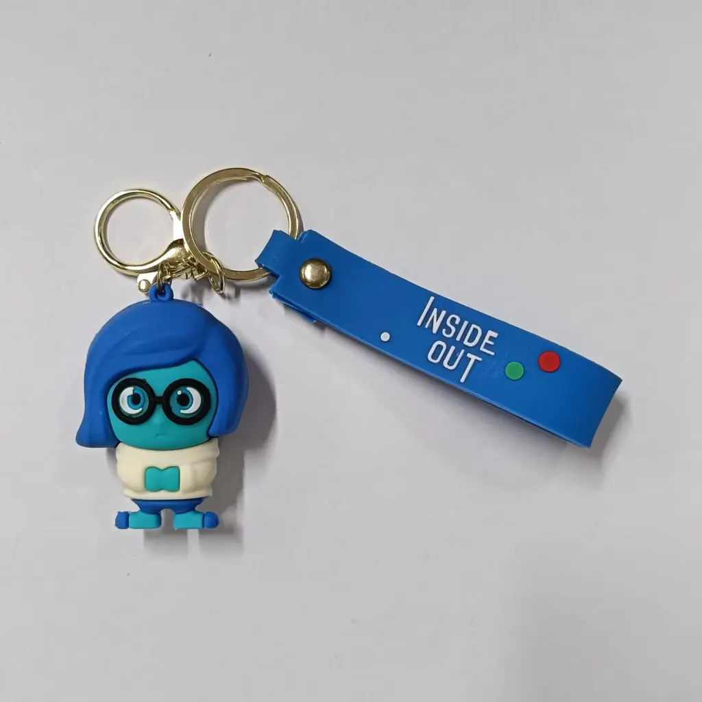 Portachiavi Inside Out con personaggio Tristezza blu in gomma 3D e targhetta logo su sfondo bianco