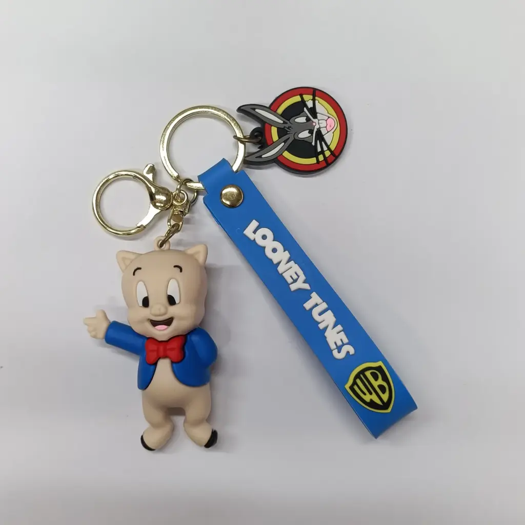 Portachiavi Looney Tunes Porky Pig in gomma morbida con nastro blu e charm colorato