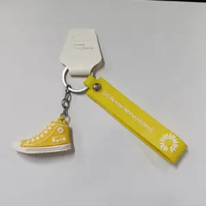 Portachiavi sneaker gialla con dettagli bianchi e linguetta decorativa con margherita