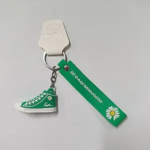 Portachiavi sneaker verde in gomma con nastro decorativo margherita gialla e anello metallico