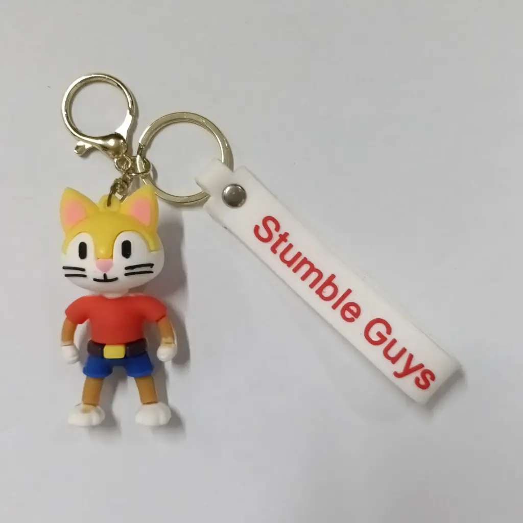 Portachiavi Stumble Guys personaggio gatto giallo Meow con targhetta bianca e moschettone dorato