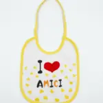 Bavetta neonato bianca con bordino giallo, scritta I Love Amici con cuore rosso e piccoli cuoricini gialli sul fondo