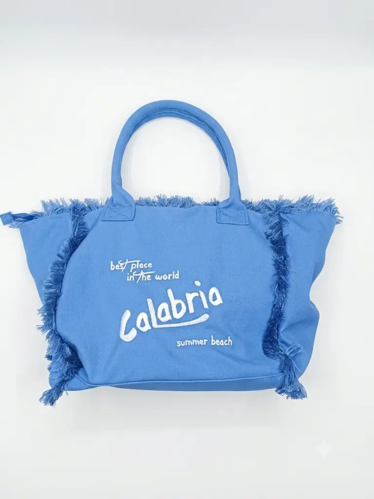 Borsa a mano in tessuto azzurro con frange laterali e scritta bianca Calabria, best place in the world, summer beach