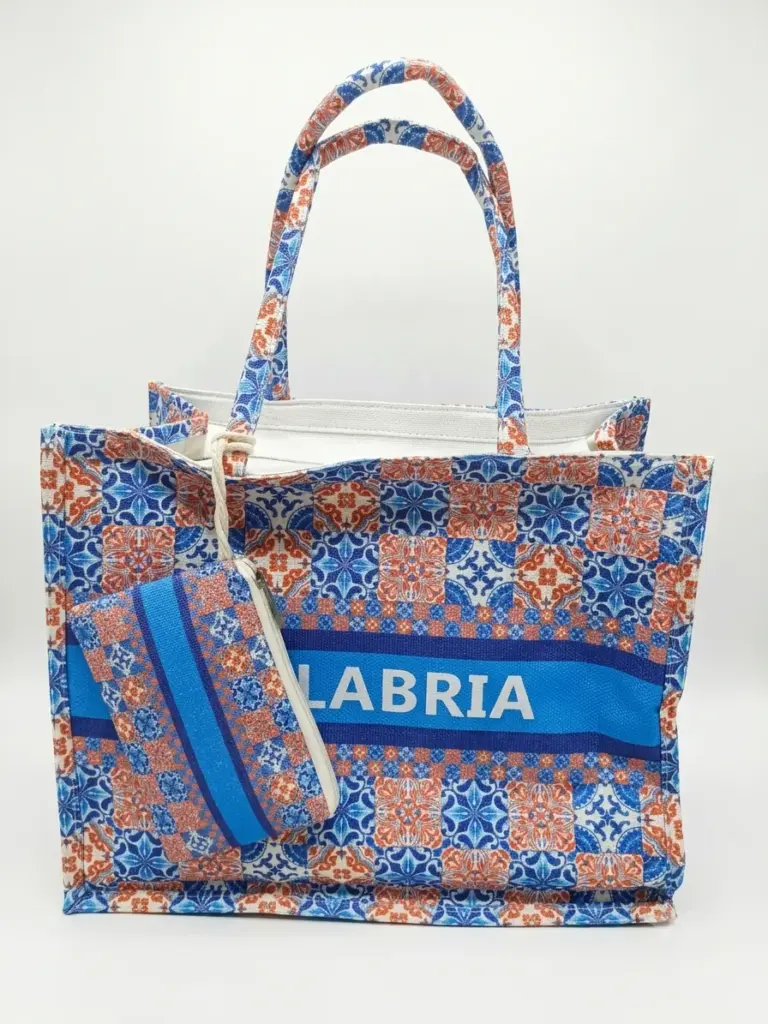 Borsa shopper in tessuto fantasia maioliche blu cobalto e arancione, scritta CALABRIA in bianco, con pochette coordinata con zip