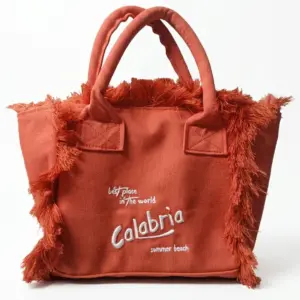 Borsa a mano in tela terracotta con frange laterali e ricamo bianco "Calabria summer beach" sul fronte