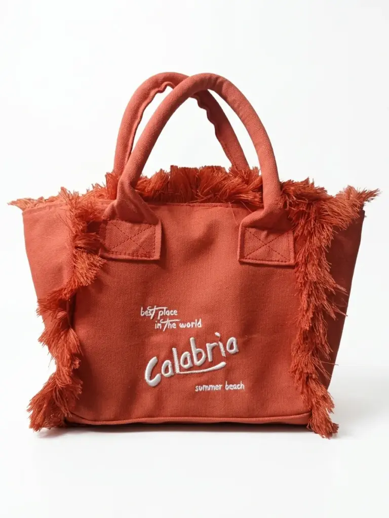 Borsa a mano in tela terracotta con frange laterali e ricamo bianco "Calabria summer beach" sul fronte