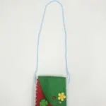 Borsetta a tracolla verde smeraldo e rosso mattone in tessuto, corda azzurra, fiore giallo, coccinella rossa e quadrifoglio verde