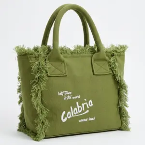 Borsa tote a mano in canvas verde oliva con frange laterali e scritta Calabria ricamata in bianco, manici rigidi e struttura rettangolare