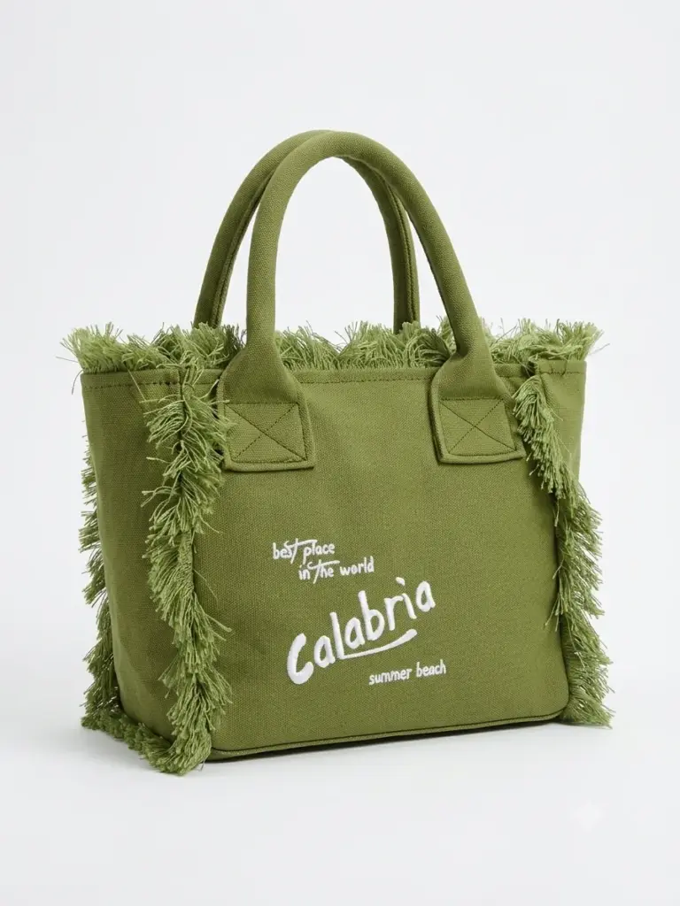Borsa tote a mano in canvas verde oliva con frange laterali e scritta Calabria ricamata in bianco, manici rigidi e struttura rettangolare