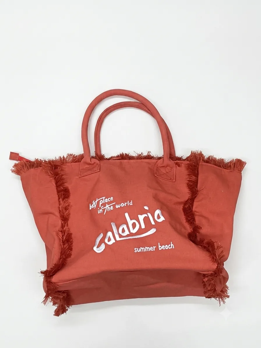 Borsa shopper in tessuto terracotta con frange laterali e scritta bianca Calabria summer beach sul fronte