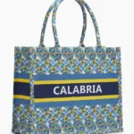 Borsa shopper in tessuto con pattern geometrico-floreale blu cobalto, azzurro e giallo e fascia navy con scritta CALABRIA in bianco