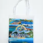 Borsa tote bianca in tela con manici lunghi bianchi e collage fotografico multicolore del Villaggio Bahja con logo a quattro stelle dorate sul fronte
