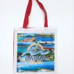Borsa tote bianca in tela con manici rossi e stampa fotografica multicolore, logo Villaggio Bahja con palma, onde e scritta BAHJA in blu