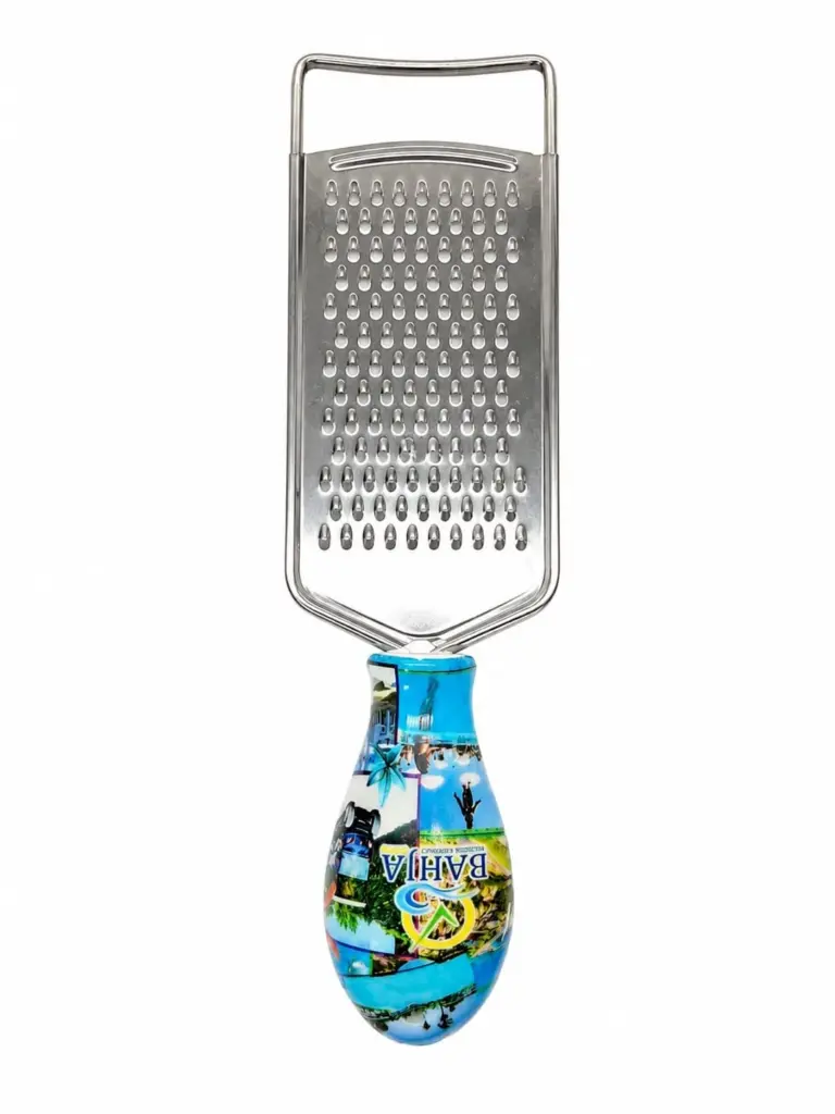 Grattugia da cucina in acciaio inox con manico ovale decorato con immagini paesaggistiche e scritta Bahja su sfondo azzurro.