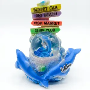 Palla di neve Calabria con delfini blu, sfera con delfino azzurro e glitter, cartelli colorati Buffet Car Big Beach Fish Market Cure Club e gabbiano