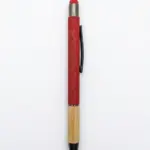Penna a sfera fusto rosso opaco con scritta Calabria incisa in corsivo, base in bambù naturale, gommino rosso, clip nera e puntale nero