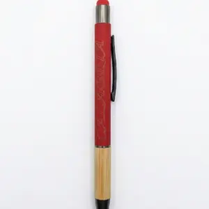 Penna a sfera fusto rosso opaco con scritta Calabria incisa in corsivo, base in bambù naturale, gommino rosso, clip nera e puntale nero