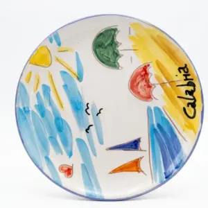 Piatto in ceramica bordo azzurro con scritta Calabria in nero, sole giallo, onde azzurre, ombrelloni verde e rosso, barche a vela blu e arancione