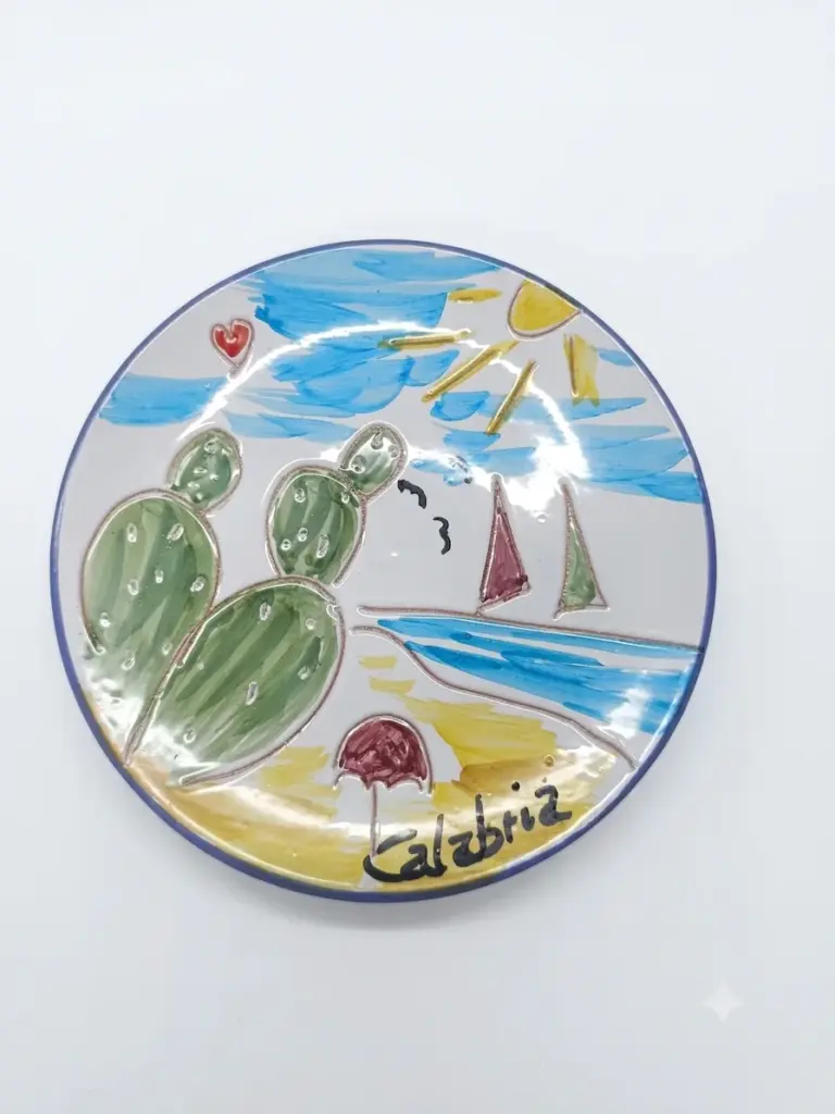 Piatto ceramica con bordo blu cobalto, spiaggia calabrese: fico d'India verde, barca a vela rosata, sole giallo, sabbia ocra e scritta Calabria