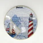 Piatto ceramica decorativo mappa nautica blu, faro a strisce rosse e bianche, barca a vela, scritta PAOLA, bordo dorato