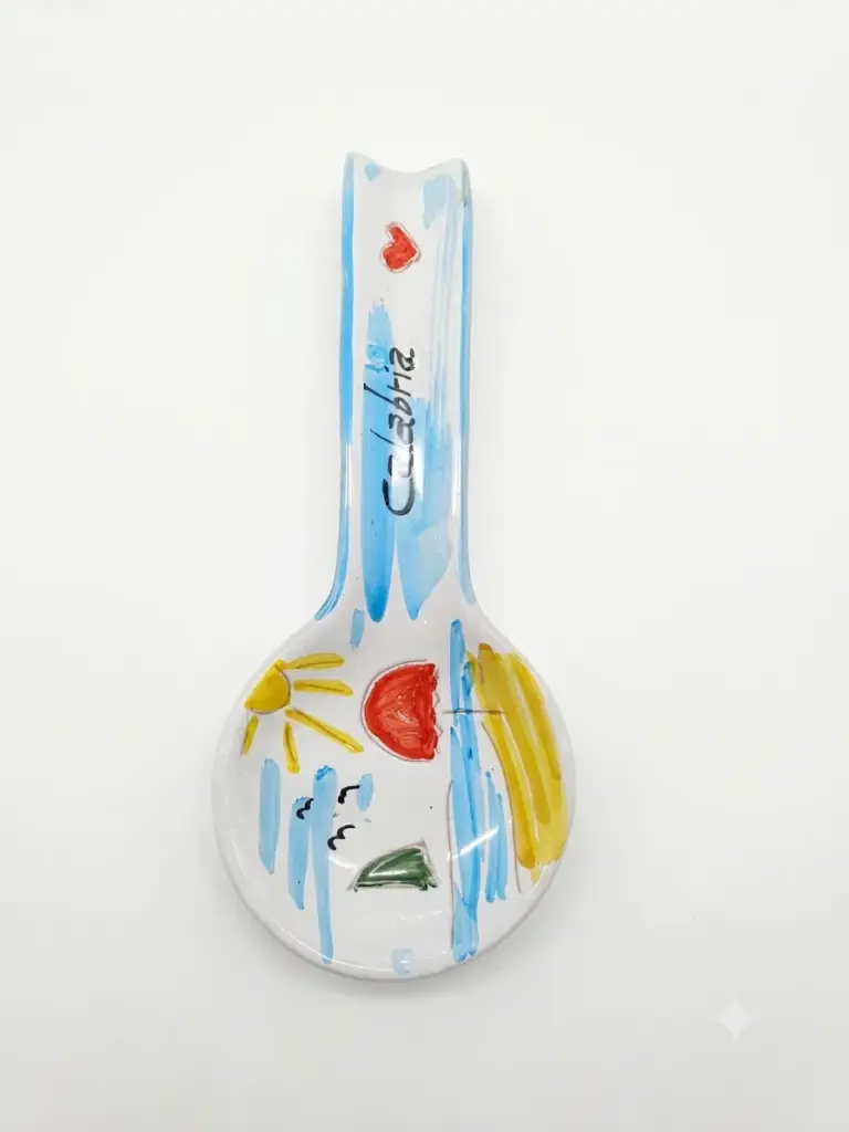 Poggiamestolo in ceramica bianca con pennellate azzurre, sole giallo, cuore rosso e scritta Calabria sul manico