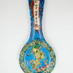 Poggiamestolo ceramica blu, mappa Calabria al centro, motivi floreali gialli sul bordo, peperoncini e scritta Calabria sul manico