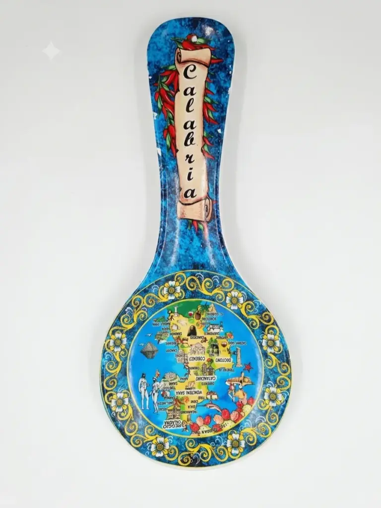 Poggiamestolo ceramica blu, mappa Calabria al centro, motivi floreali gialli sul bordo, peperoncini e scritta Calabria sul manico
