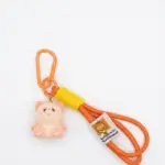 Portachiavi con moschettone arancione, cordino paracord bicolore arancione-giallo e ciondolo gattino morbido color pesca con dettagli rosa