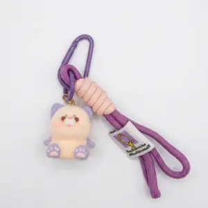 Portachiavi gattino peluche crema con orecchie e zampette viola, cordino intrecciato rosa antico, frange viola e moschettone metallico viola