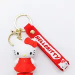 Portachiavi Hello Kitty figura tridimensionale in abito rosso con fiocco, cinturino in gomma rossa con scritta HELLO KITTY e anello metallico dorato