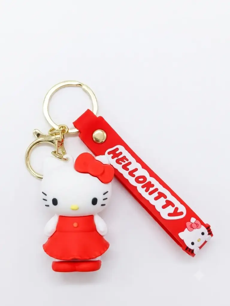 Portachiavi Hello Kitty figura tridimensionale in abito rosso con fiocco, cinturino in gomma rossa con scritta HELLO KITTY e anello metallico dorato