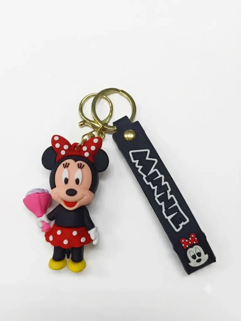 Portachiavi Minnie in gomma, fiocco rosso a pois, gonna rossa, mazzetto di fiori rosa, targhetta nera MINNIE e doppio anello dorato
