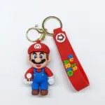 Portachiavi Super Mario: figura 3D con cappello rosso e salopette blu che regge un fungo rosso, cinturino in silicone rosso con scritta multicolore