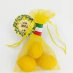 Tre saponette gialle a forma di limone in sacchetto organza gialla, etichetta circolare Limone Bahja con illustrazioni di agrumi, nastro tricolore