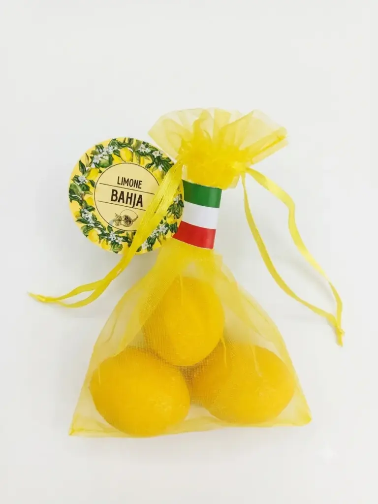 Tre saponette gialle a forma di limone in sacchetto organza gialla, etichetta circolare Limone Bahja con illustrazioni di agrumi, nastro tricolore