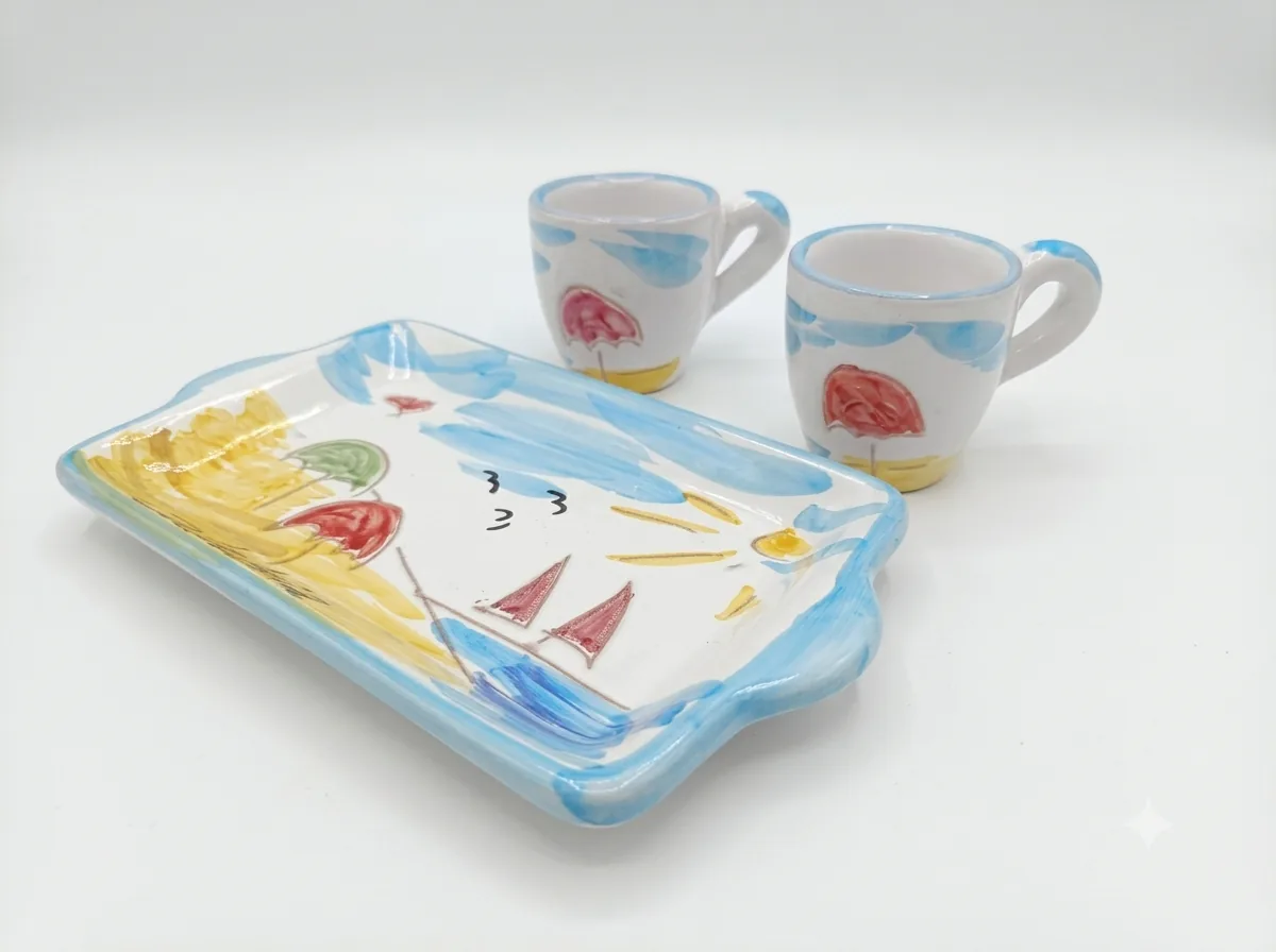Set tre pezzi ceramica bianca: vassoio rettangolare e due tazzine con bordi azzurri, decori naif ombrelloni colorati, velieri rossi e sole