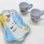 Set tazzine caffè ceramica bianca con vassoio sagomato ondulato, decori azzurri, ombrelloni colorati e scritta Calabria in nero