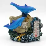 Soprammobile in resina con due delfini blu, base corallina marina con glitter dorati, teschio bianco e termometro Celsius Fahrenheit
