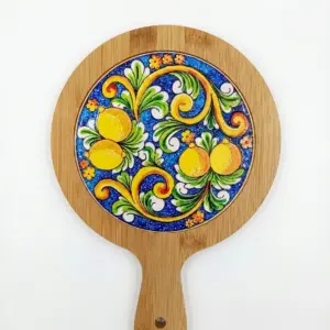 Sottopentola rotondo in bambù con piastrella ceramica centrale: limoni gialli, foglie verdi, volute arancioni e fiori su fondo blu cobalto