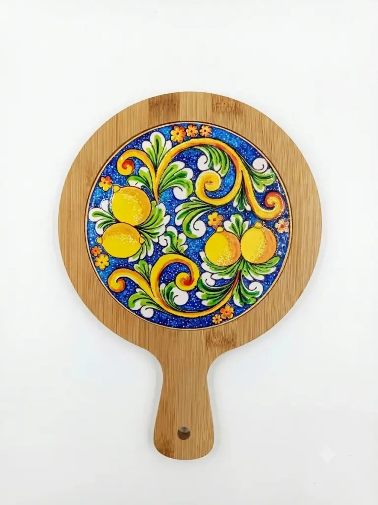 Sottopentola rotondo in bambù con piastrella ceramica centrale: limoni gialli, foglie verdi, volute arancioni e fiori su fondo blu cobalto