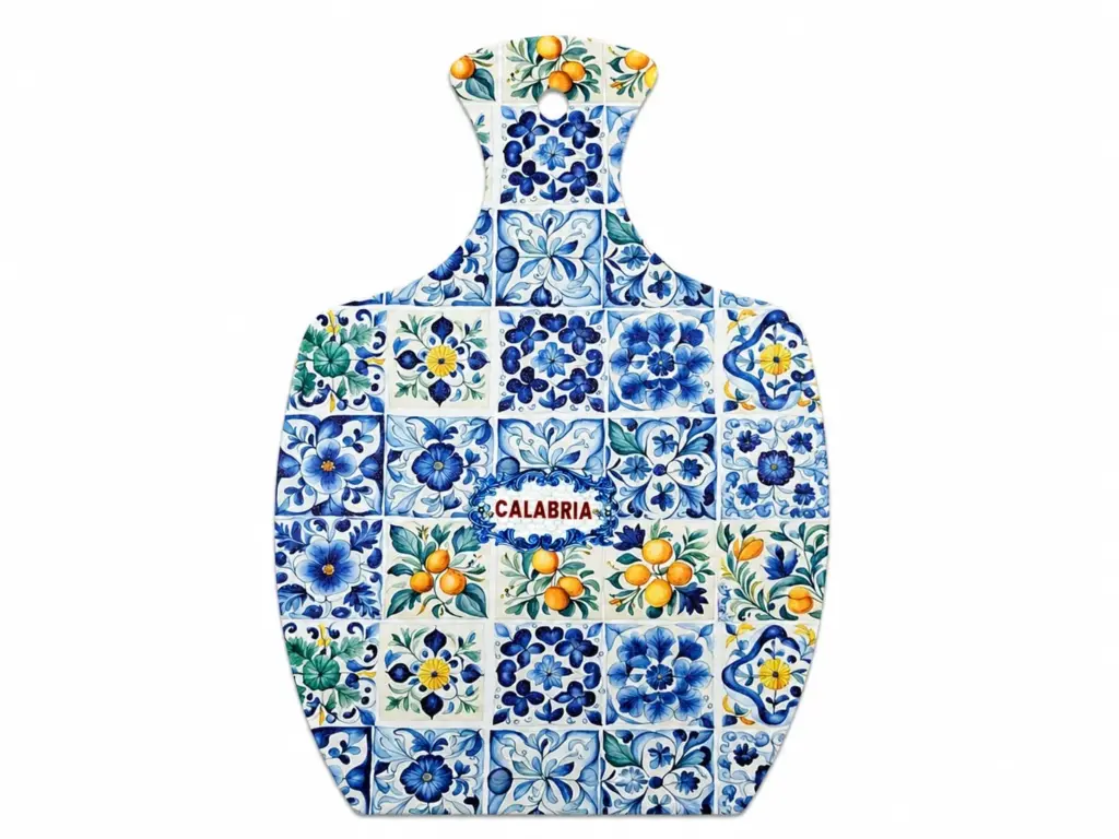 Tagliere a paletta con mosaico di piastrelle floreali blu, verdi e arancio e scritta Calabria al centro in lettere rosse.