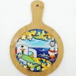 Sottopentola rotondo bambù con inserto ceramica: paesaggio marino, casetta bianca, faro a strisce e mare blu con onde stilizzate