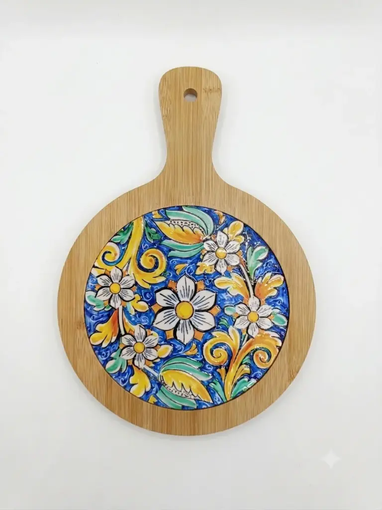 Tagliere sottopentola rotondo in bambù con ceramica smaltata: fiori bianchi su fondo blu cobalto, volute gialle e foglie verdi