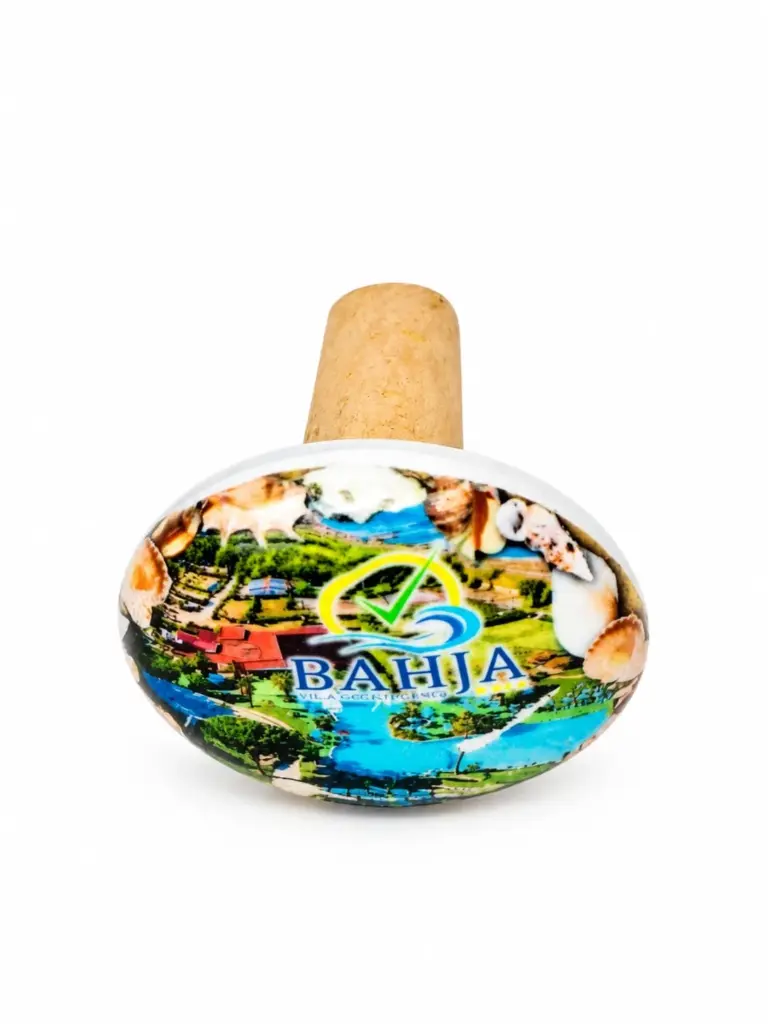 Tappo da bottiglia con corpo ovale in ceramica decorata con logo Bahja, veduta verde e conchiglie, cono in sughero naturale nocciola.